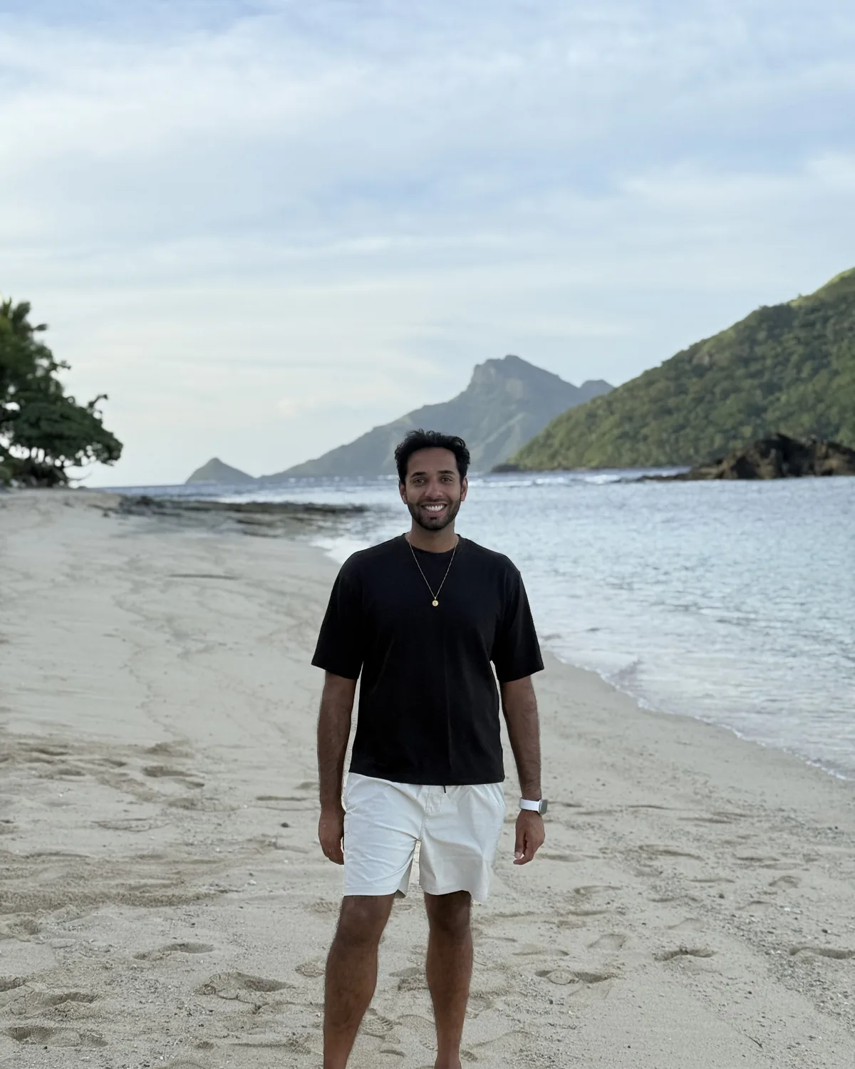 Kiran smiling on a beach in St Lucia
