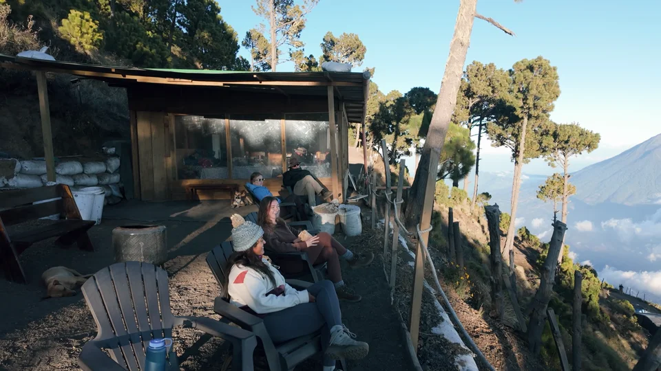 Wooden cabin base camp on Acatenango with hikers relaxing outside, Guatemala