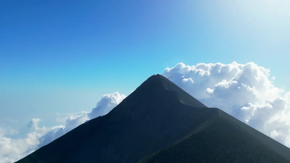 Volcano peak rising above the clouds, seen from the plane arriving in Guatemala