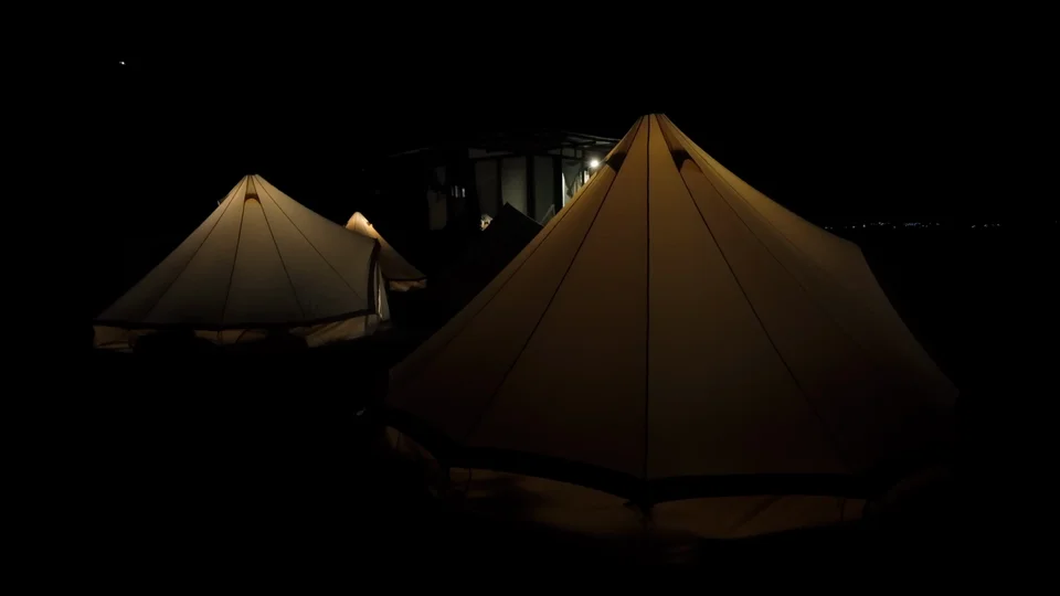 Glamping tents lit up at night at Free Cerveza hostel, Lake Atitlán, Guatemala