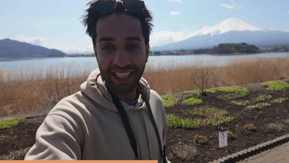 Kiran smiling by the lake with Mount Fuji in the background