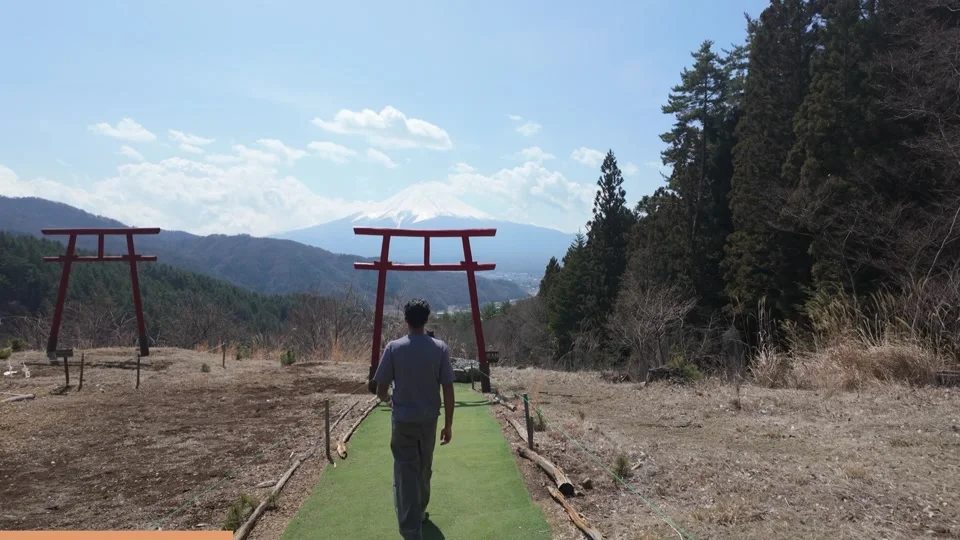 Walking toward the red torii gates with Mount Fuji behind them