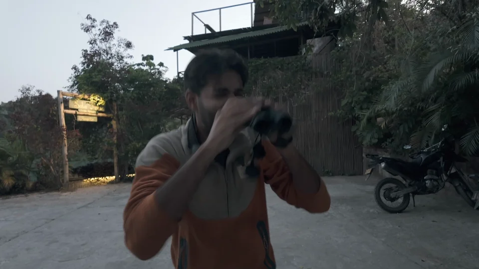 Birdwatching guide with binoculars near a hostel in Minca, Colombia