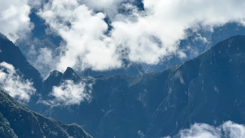 First distant view of Machu Picchu through the clouds from Llactapata