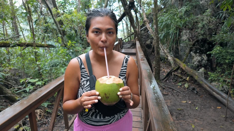 Drinking a fresh coconut on the boardwalk at Semuc Champey, Guatemala