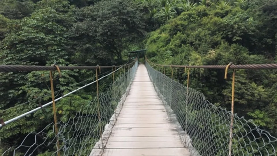 Crossing a suspension bridge on the Salkantay Trek