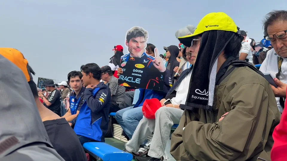 Japanese F1 fans in the grandstand at Suzuka with a homemade driver cutout