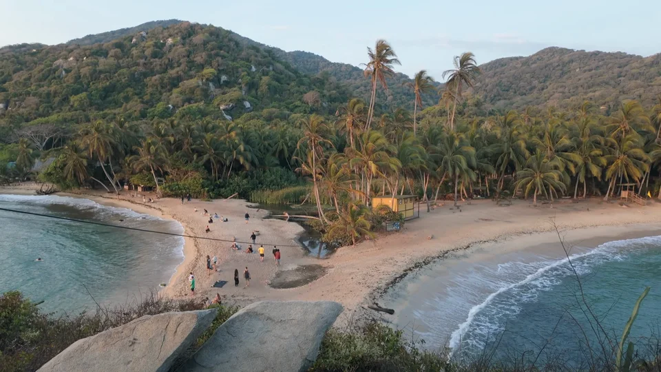 Aerial view of a palm-lined beach cove in Tayrona National Park, Colombia