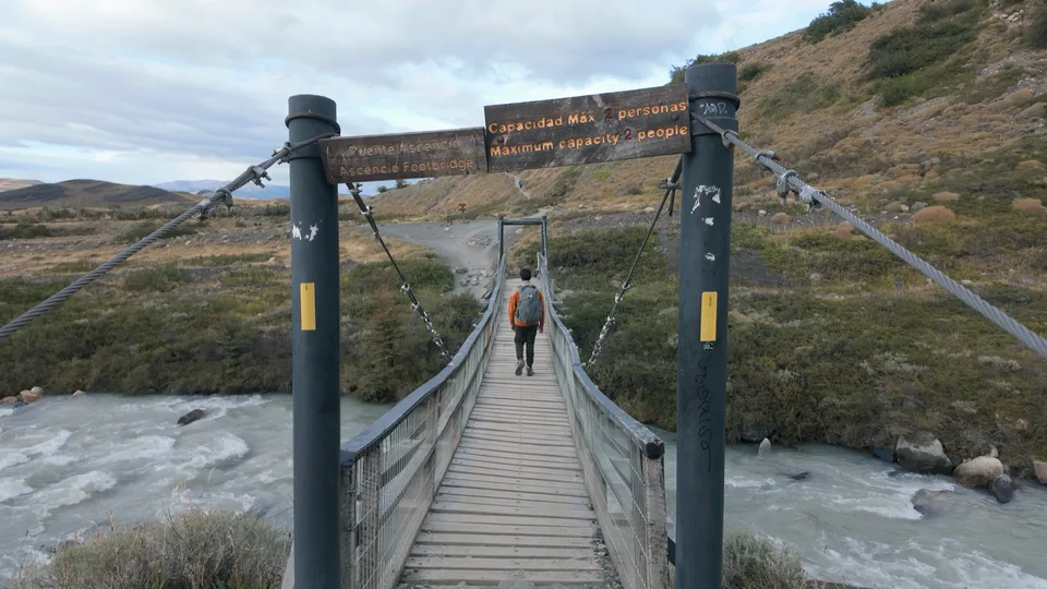 Crossing the Ascencio Footbridge over glacial rapids on the W Trek