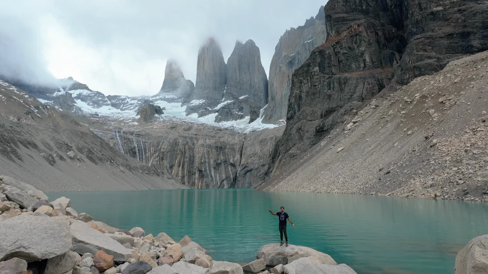 First view of the granite towers of Torres del Paine above a turquoise glacial lagoon