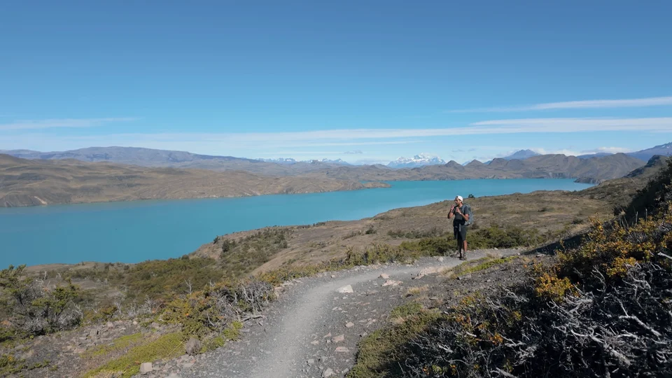 Hiker on the trail above the turquoise waters of Lago Nordenskjöld, Torres del Paine