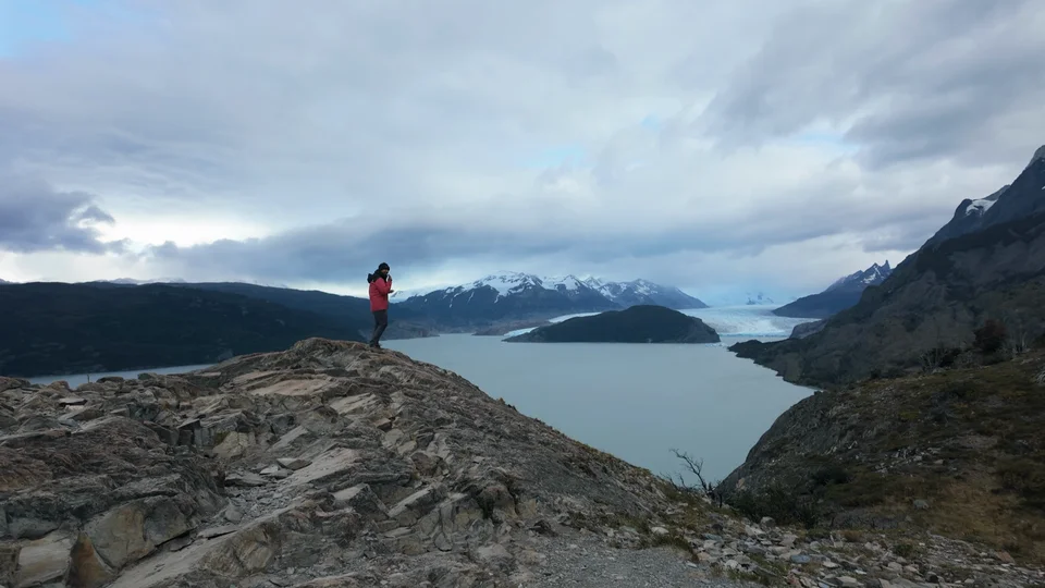 Hiker overlooking Lake Grey with the Grey Glacier visible in the distance, Torres del Paine
